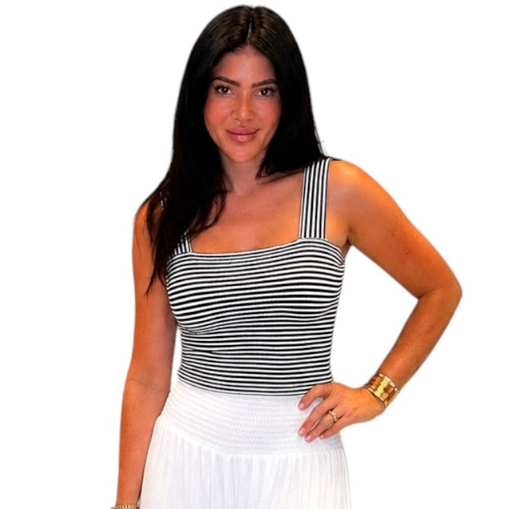 Woman wearing a black and white striped tank top on a white background