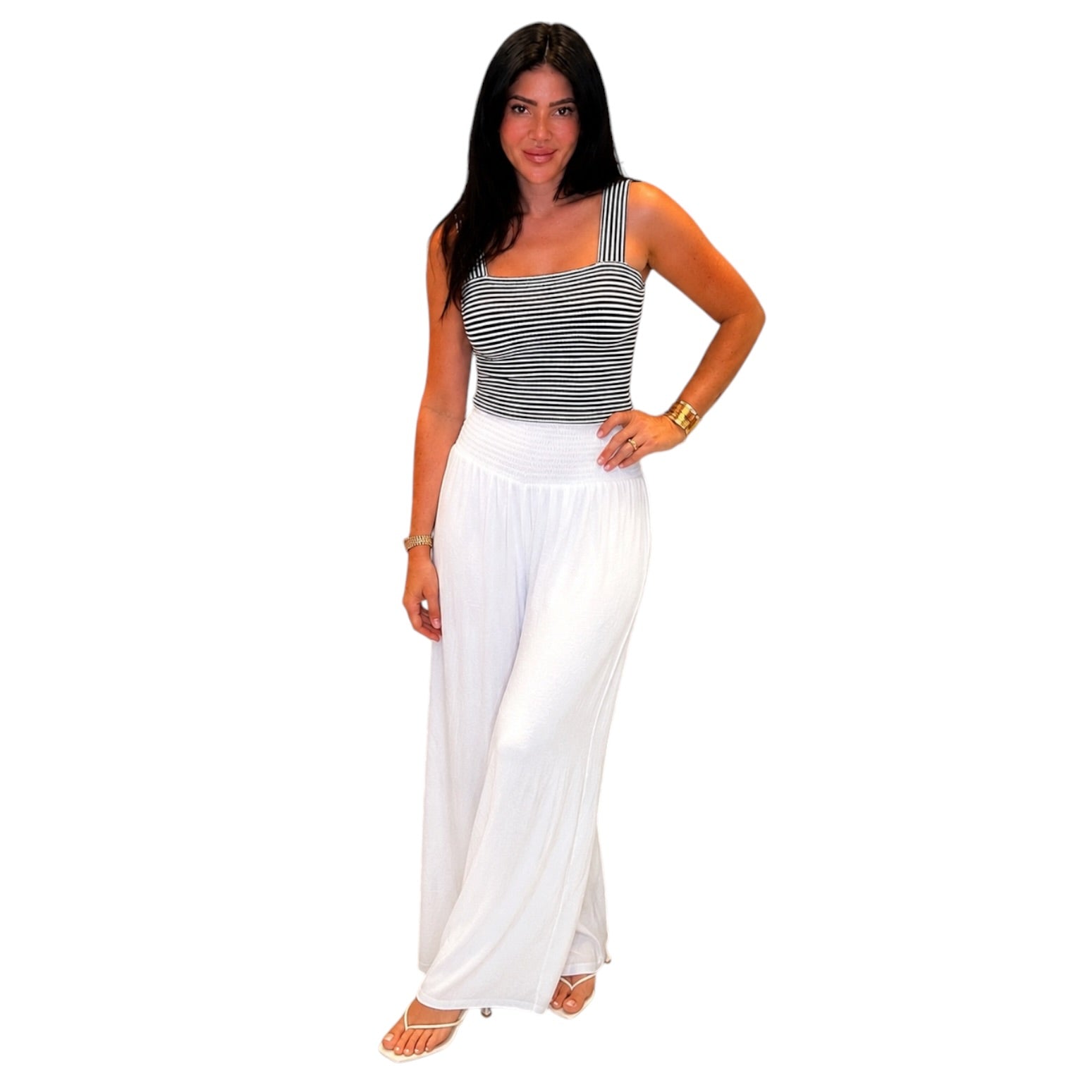 Woman wearing a striped top and white pants on a white background