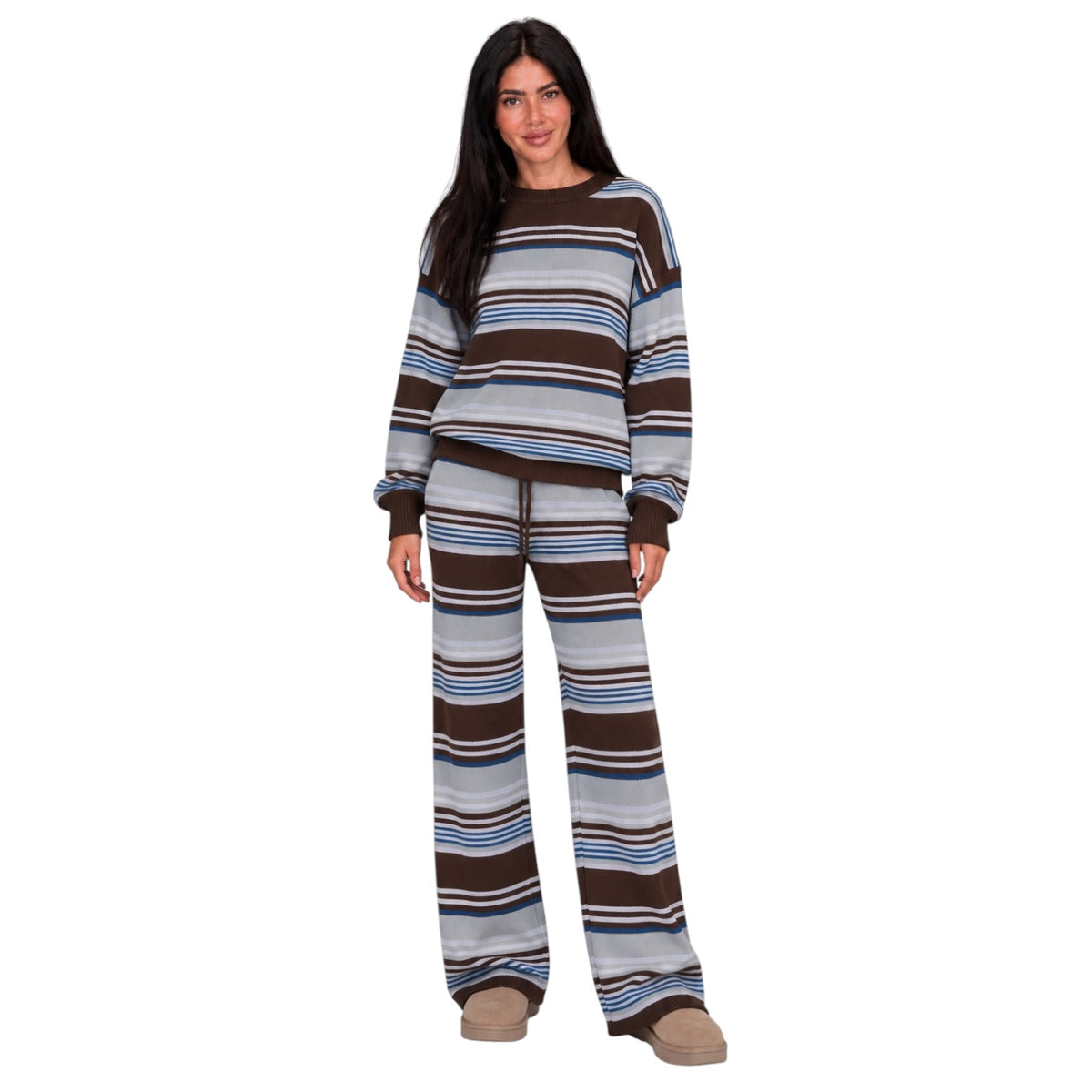 A woman modeling a matching two-piece lounge set with horizontal stripes in brown, beige, light blue, and white, paired with tan slip-on shoes, against a plain white background.