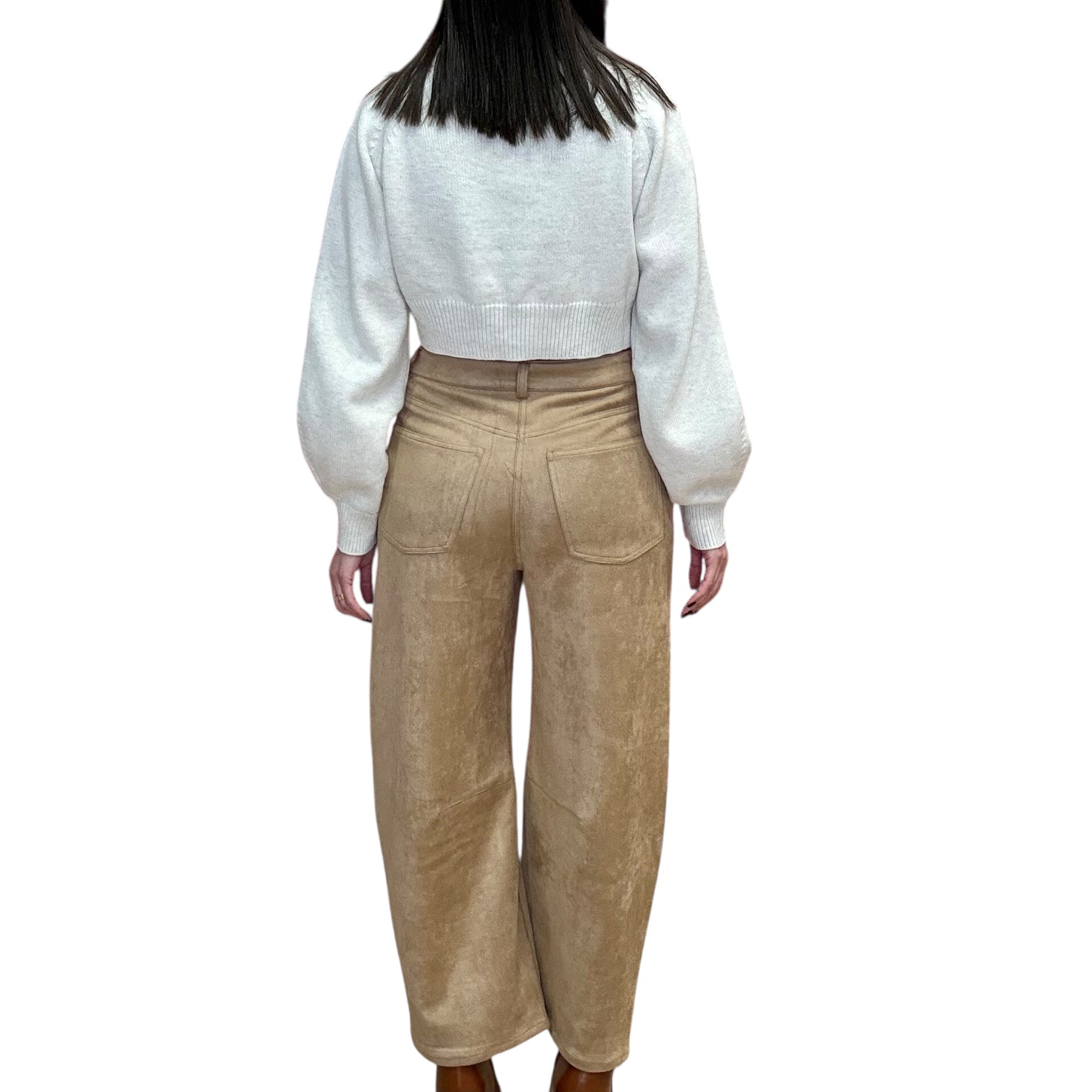 Person wearing a off white sweater and came suede pants on a white background
