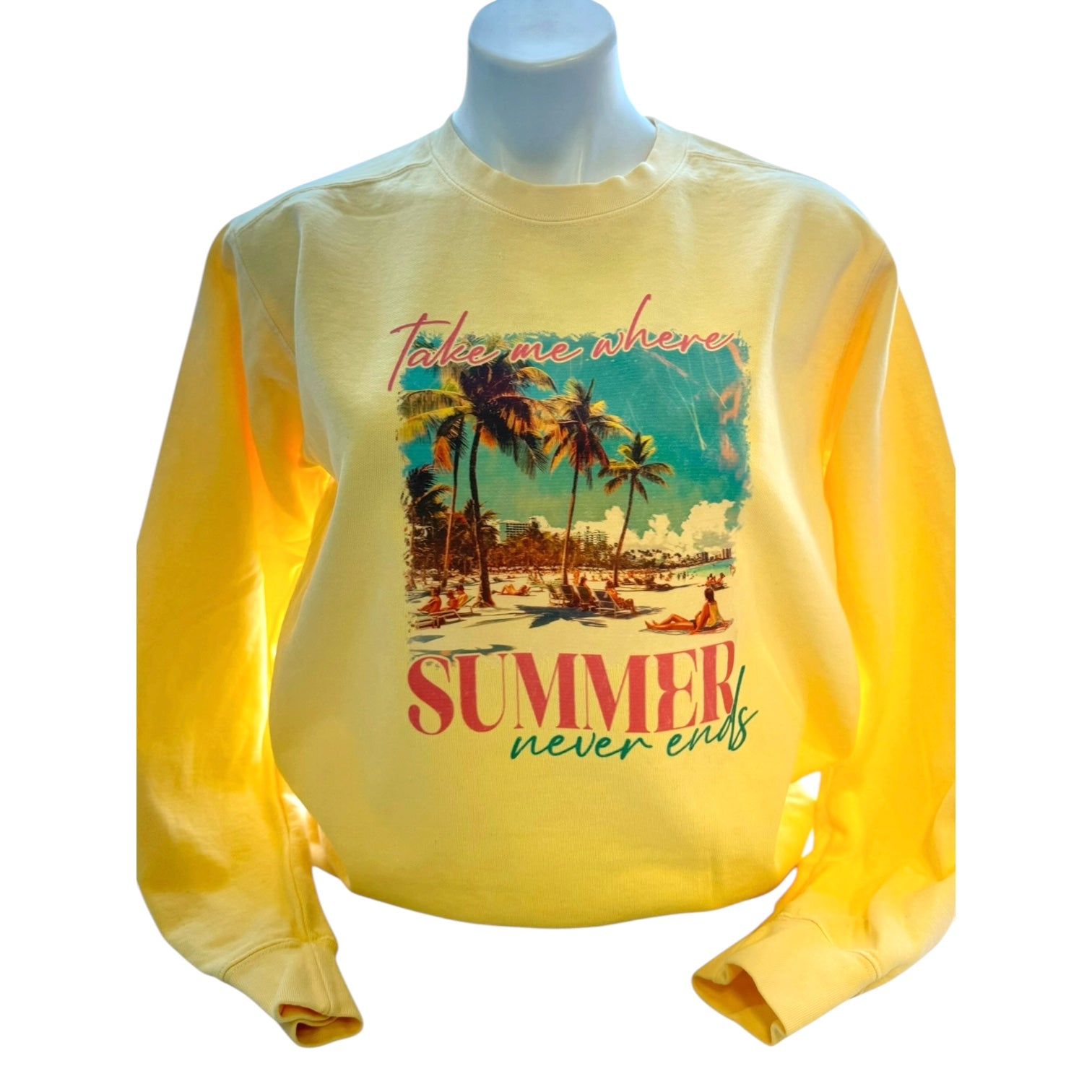 Yellow sweatshirt with a beach graphic and text on a mannequin against a white background