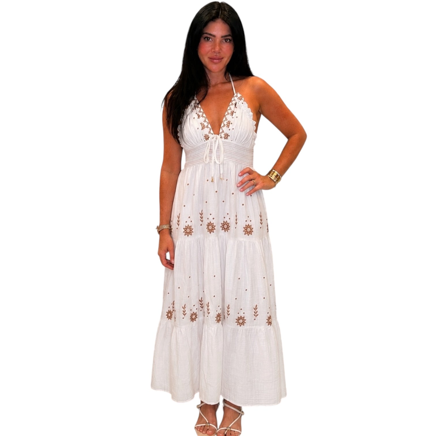Woman wearing a white dress with floral embroidery on a white background