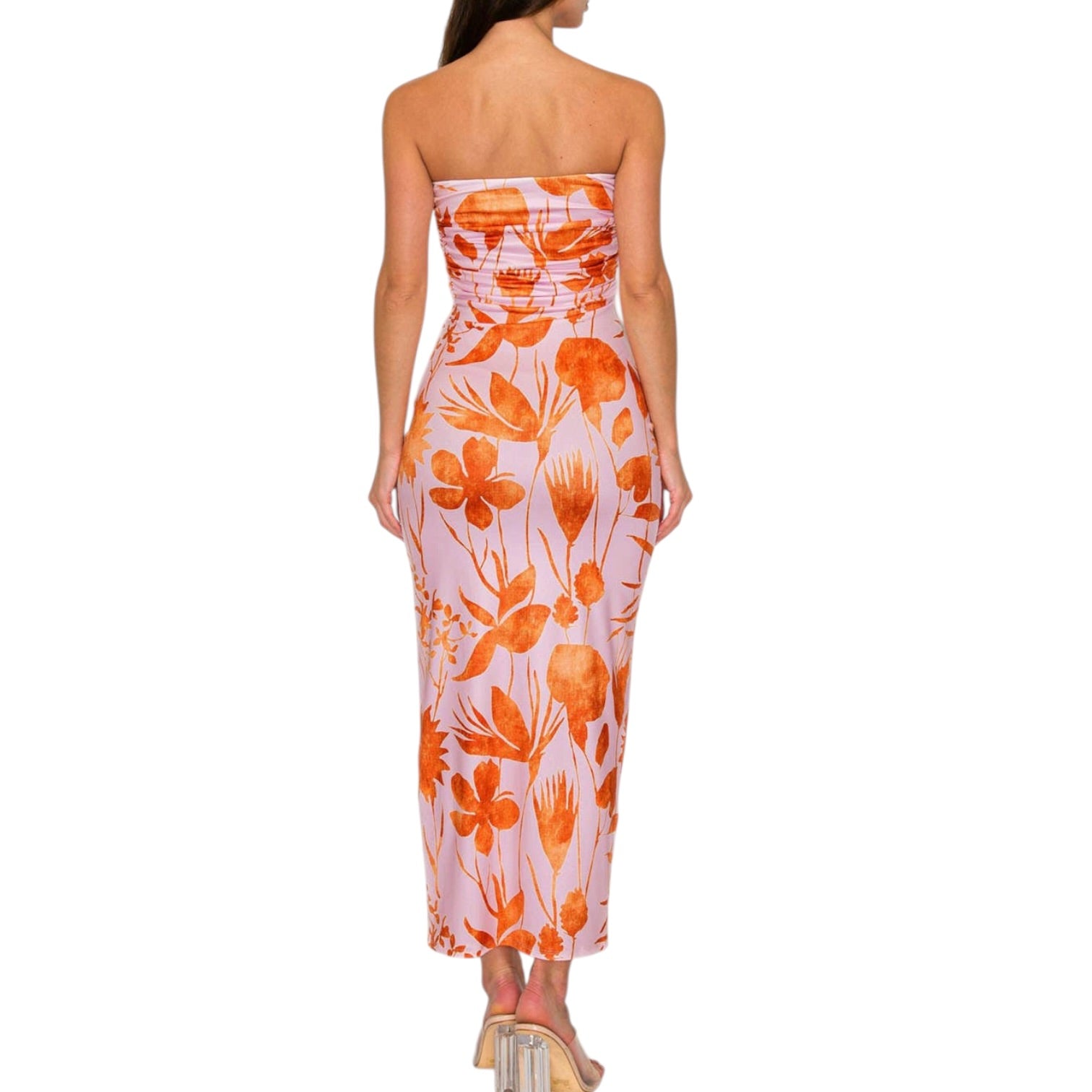 Woman wearing a strapless floral dress with orange and pink pattern on a white background