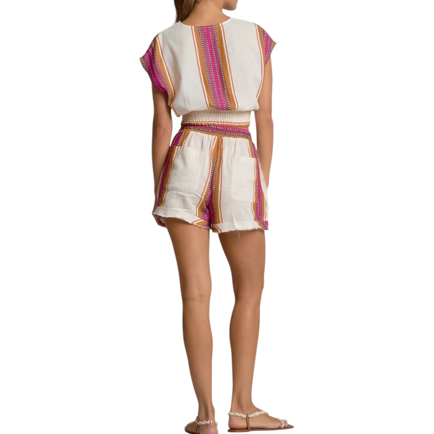 Woman wearing a white outfit with colorful stripes on a white background