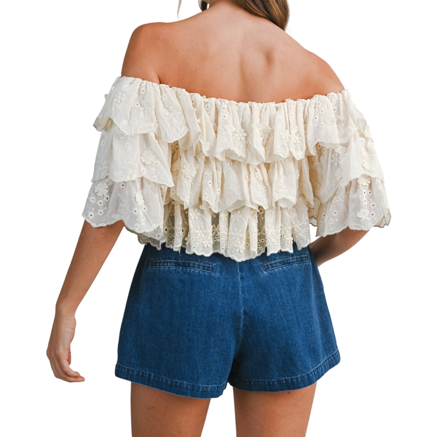 woman wearing tiered off shoulder lace top with pleated denim shorts