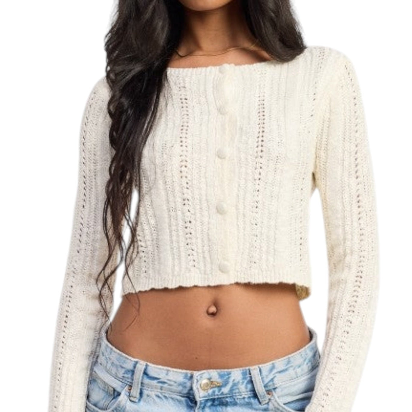 Woman wearing a cream-colored knitted crop top and denim shorts on a white background