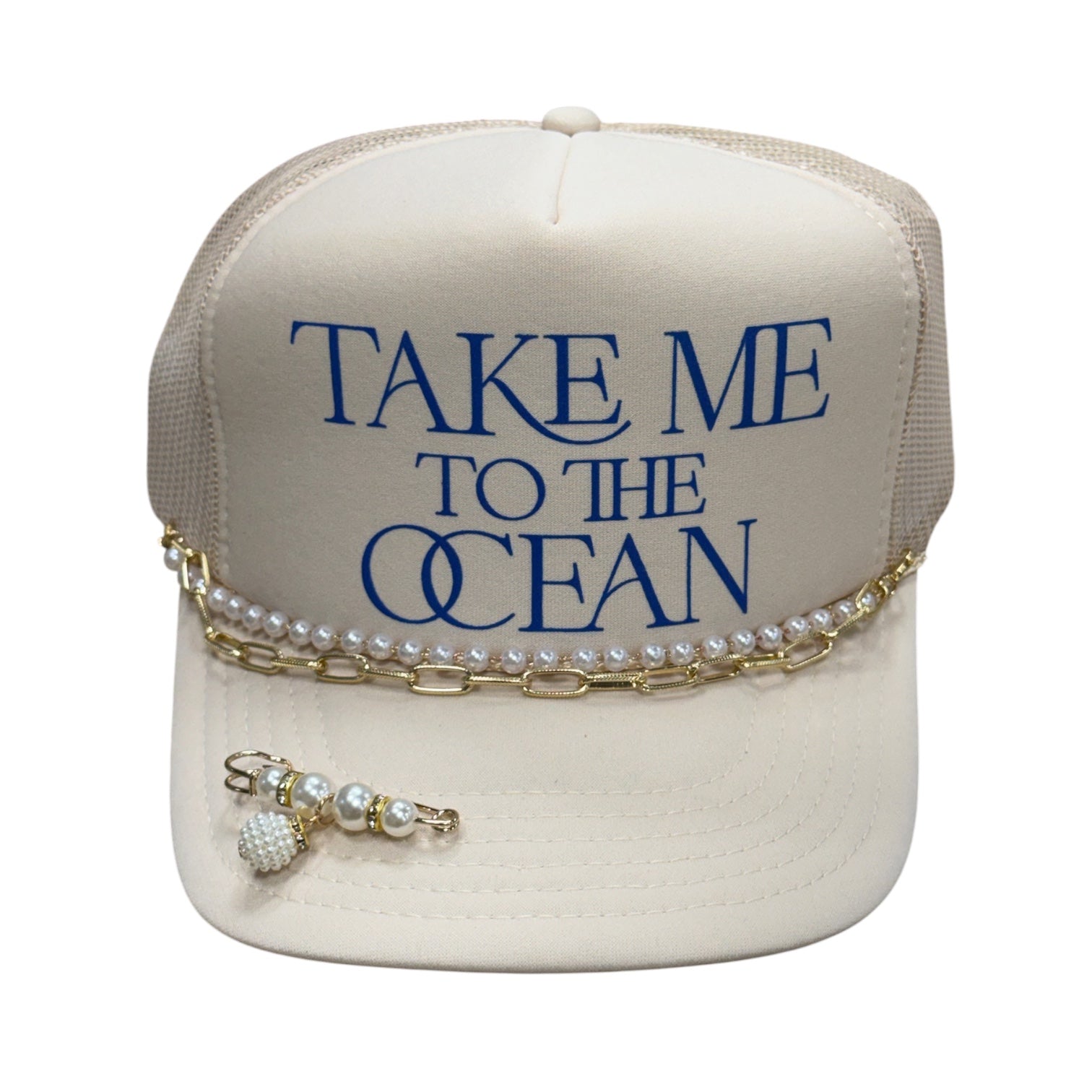 Beige cap with 'Take Me to the Ocean' text and pearl and chain accessories on a white background