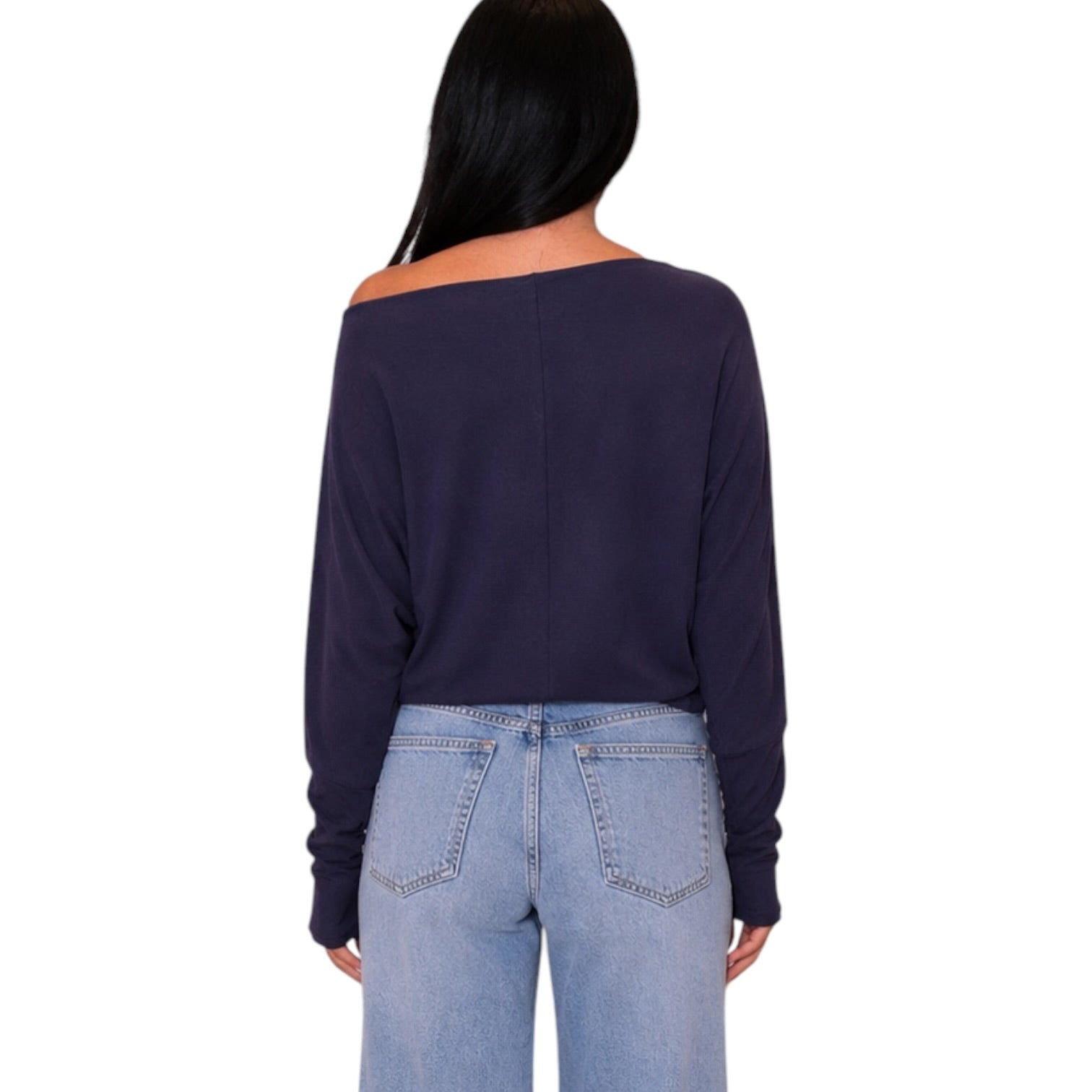 A woman shown from the back wearing a dark navy off-the-shoulder long-sleeve crop top and light blue jeans against a plain white background.