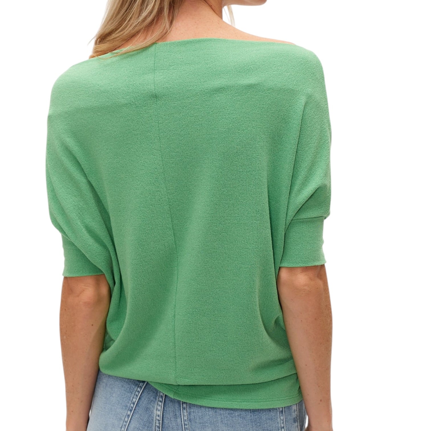 Green top worn by a person on a white background