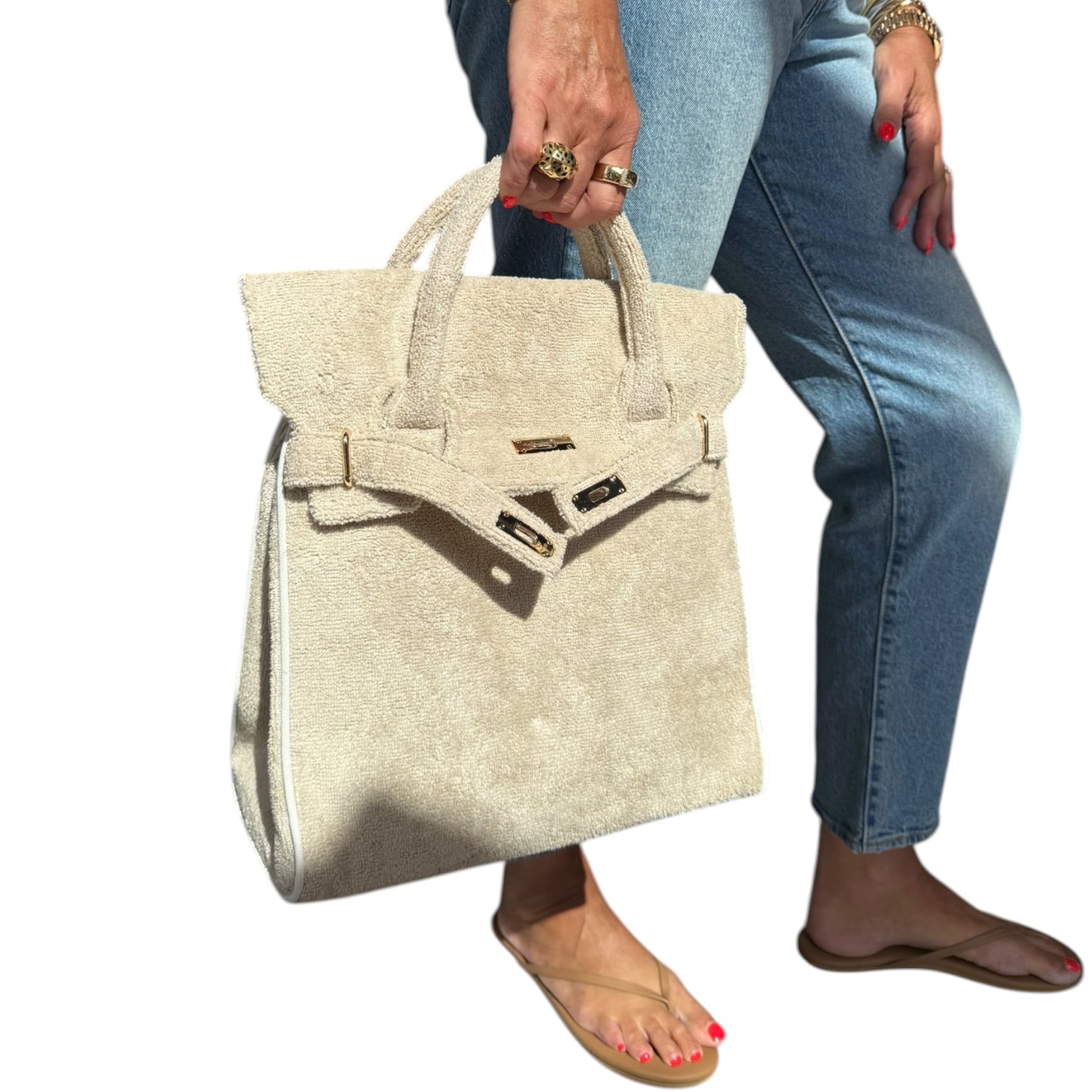 Person holding a beige handbag with a white background