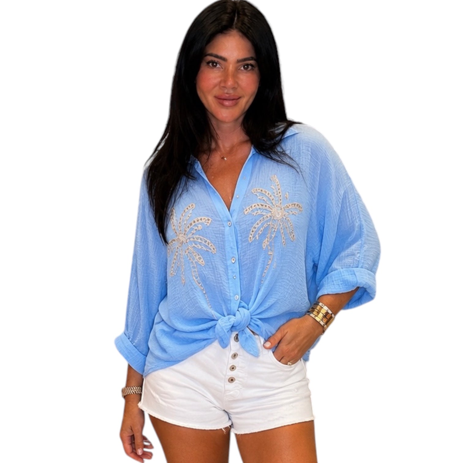 Woman wearing a light blue cover-up with palm tree designs on a white background