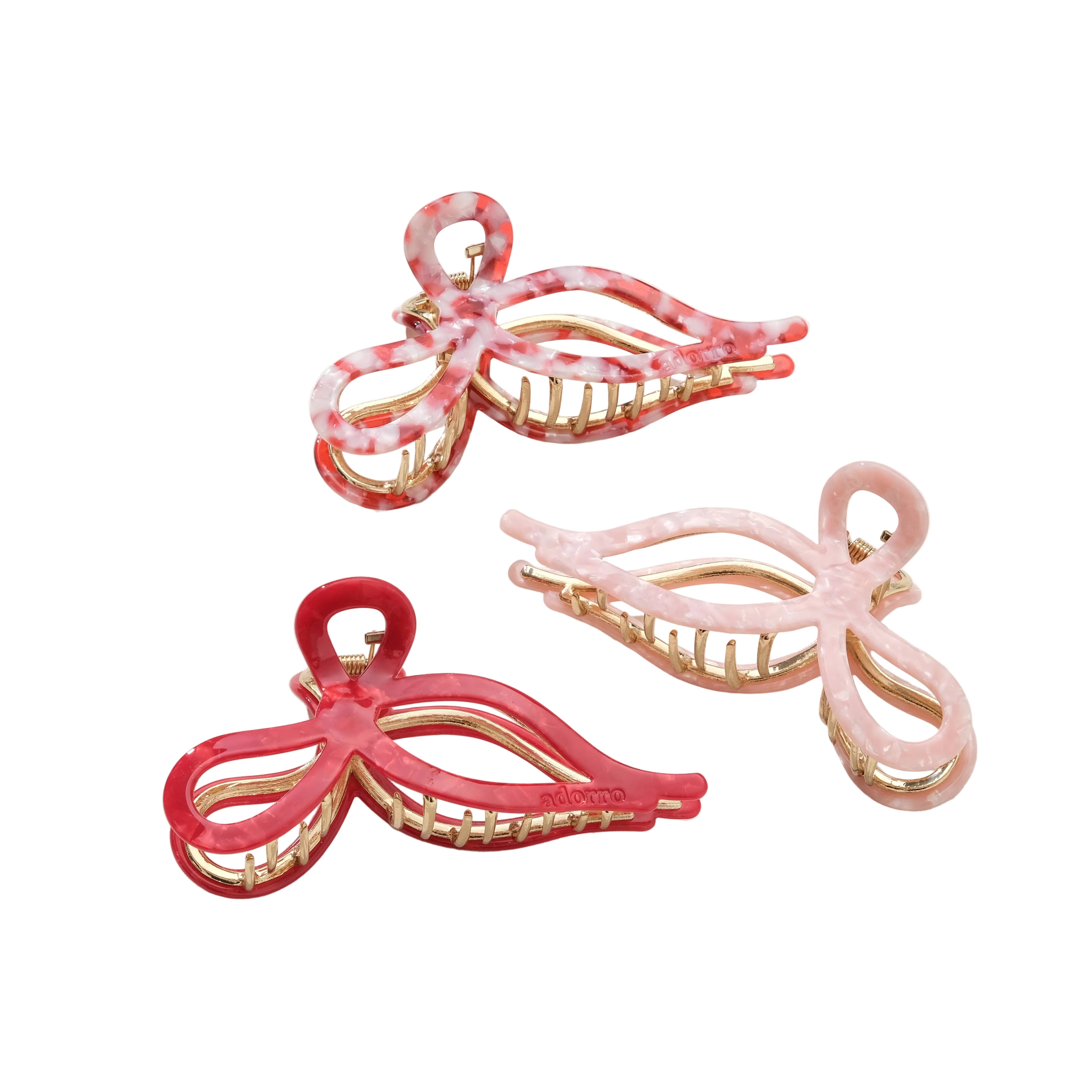 Three pink and gold hair clips on a white background
