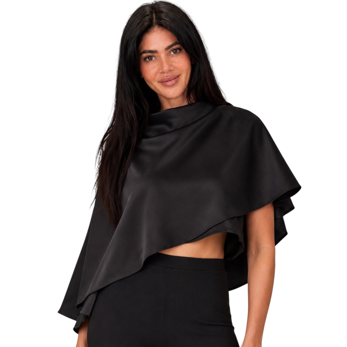 A woman modeling a black satin-like draped cape top with layered ruffle edges, paired with black bottoms, against a plain white background.