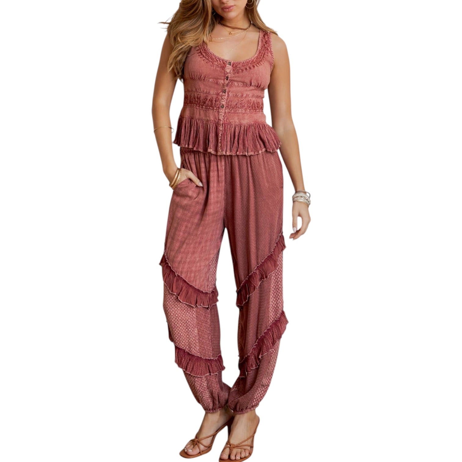 Woman wearing a pink ruffled jumpsuit on a white background