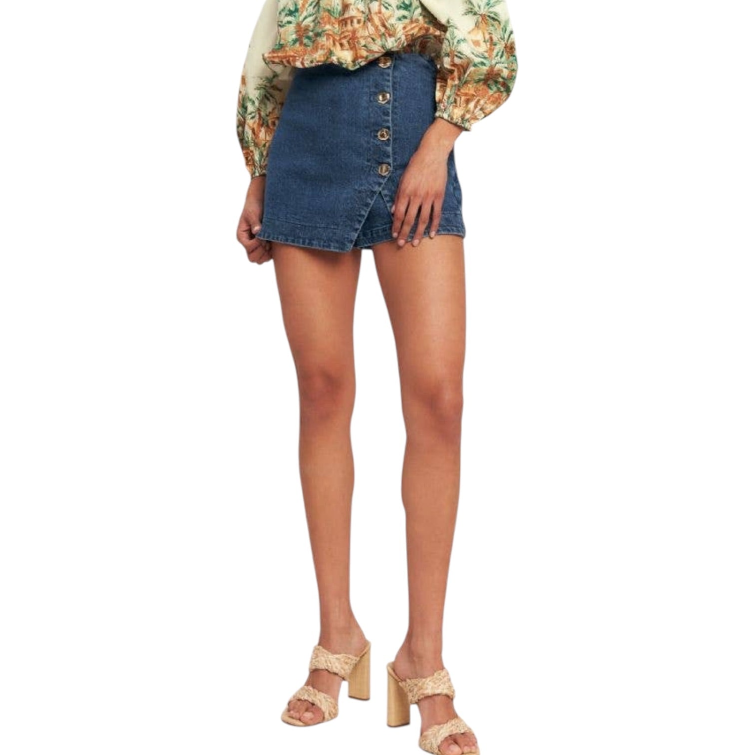 woman wearing denim skort with gold buttons on white background