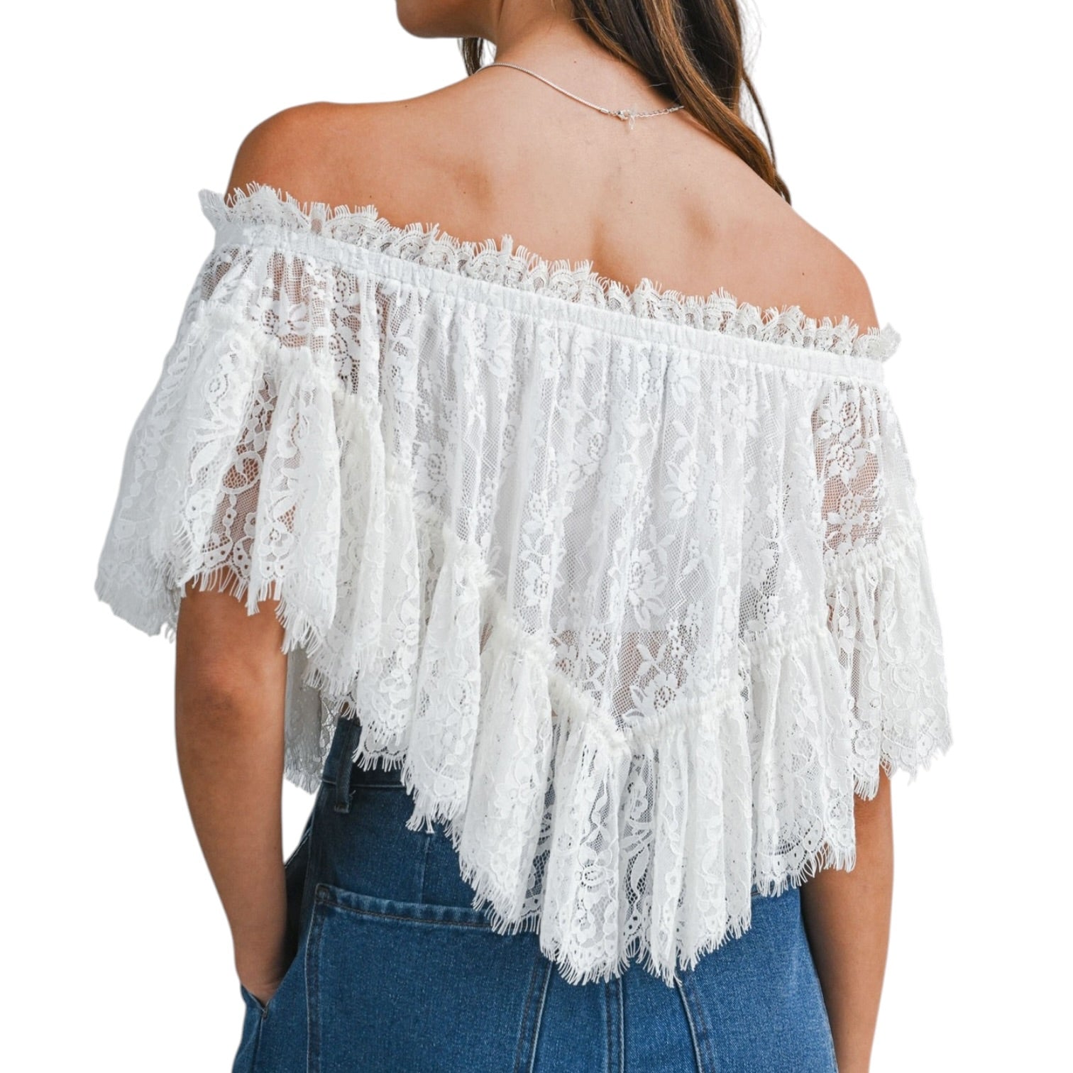 White lace off-shoulder top worn by a person on a white background
