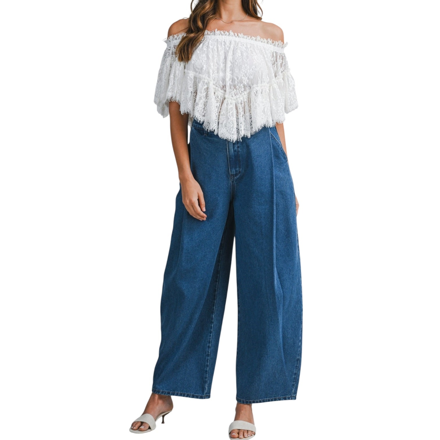 Woman wearing a white off-shoulder top with lace and blue jeans on a white background