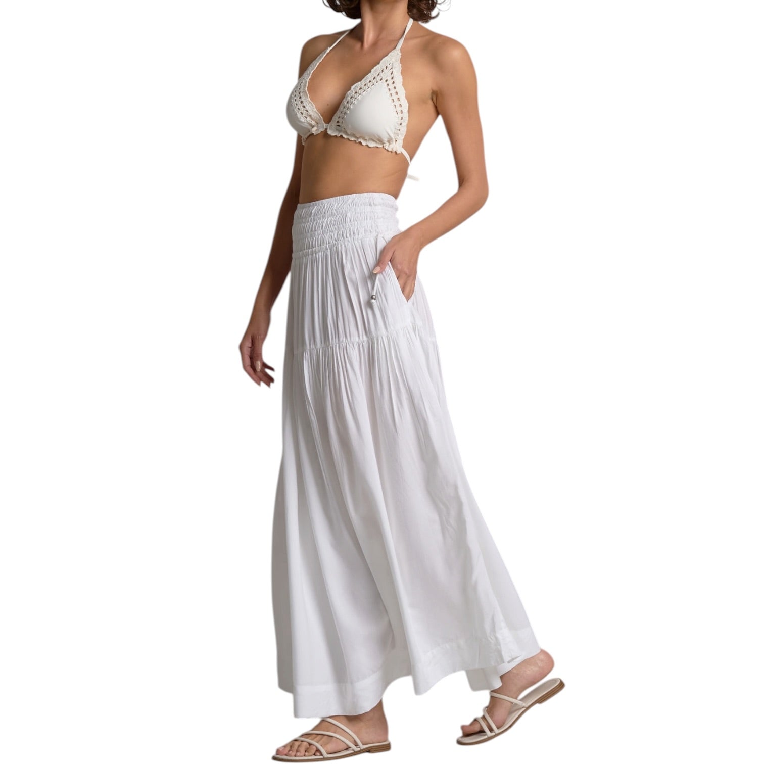 Woman wearing a white halter top and long skirt on a white background