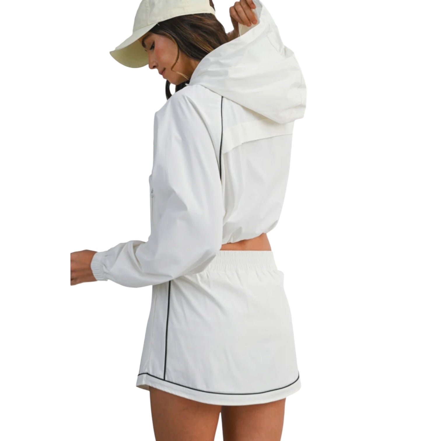 Woman wearing a white outfit with black trim on a white background