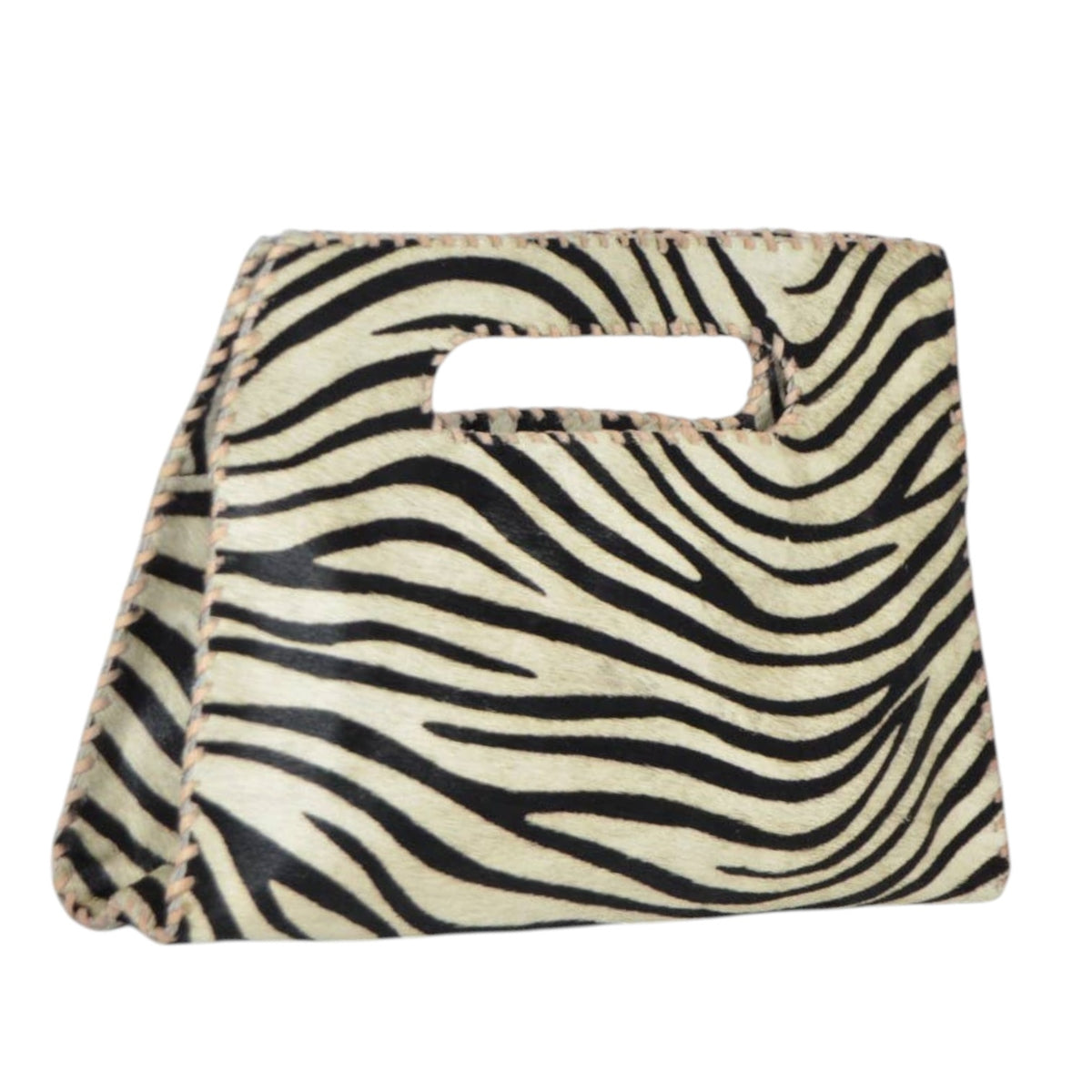 A zebra-print handbag with a beige and black animal pattern, featuring a cutout handle on the front, set against a plain white background.