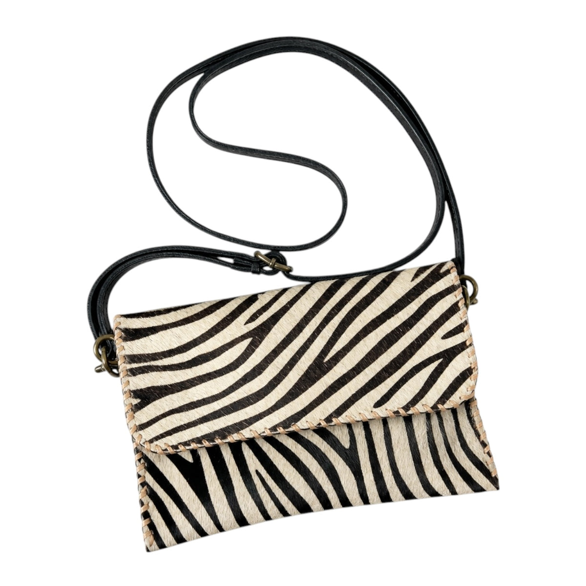 A small crossbody handbag with a black and beige zebra print pattern, featuring a black leather strap and gold-tone hardware, shown on a plain white background.
