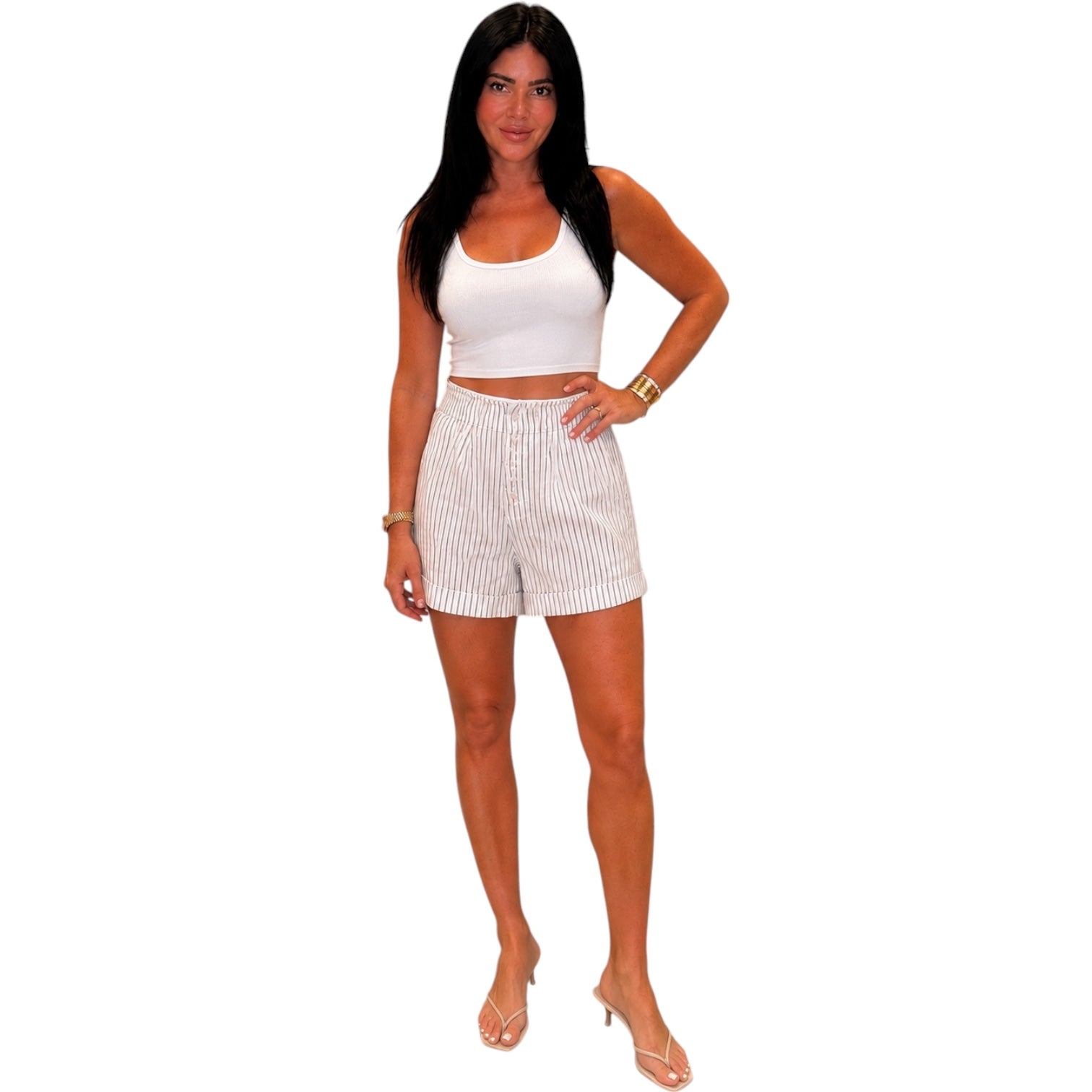 Woman wearing a white sleeveless top and shorts on a white background