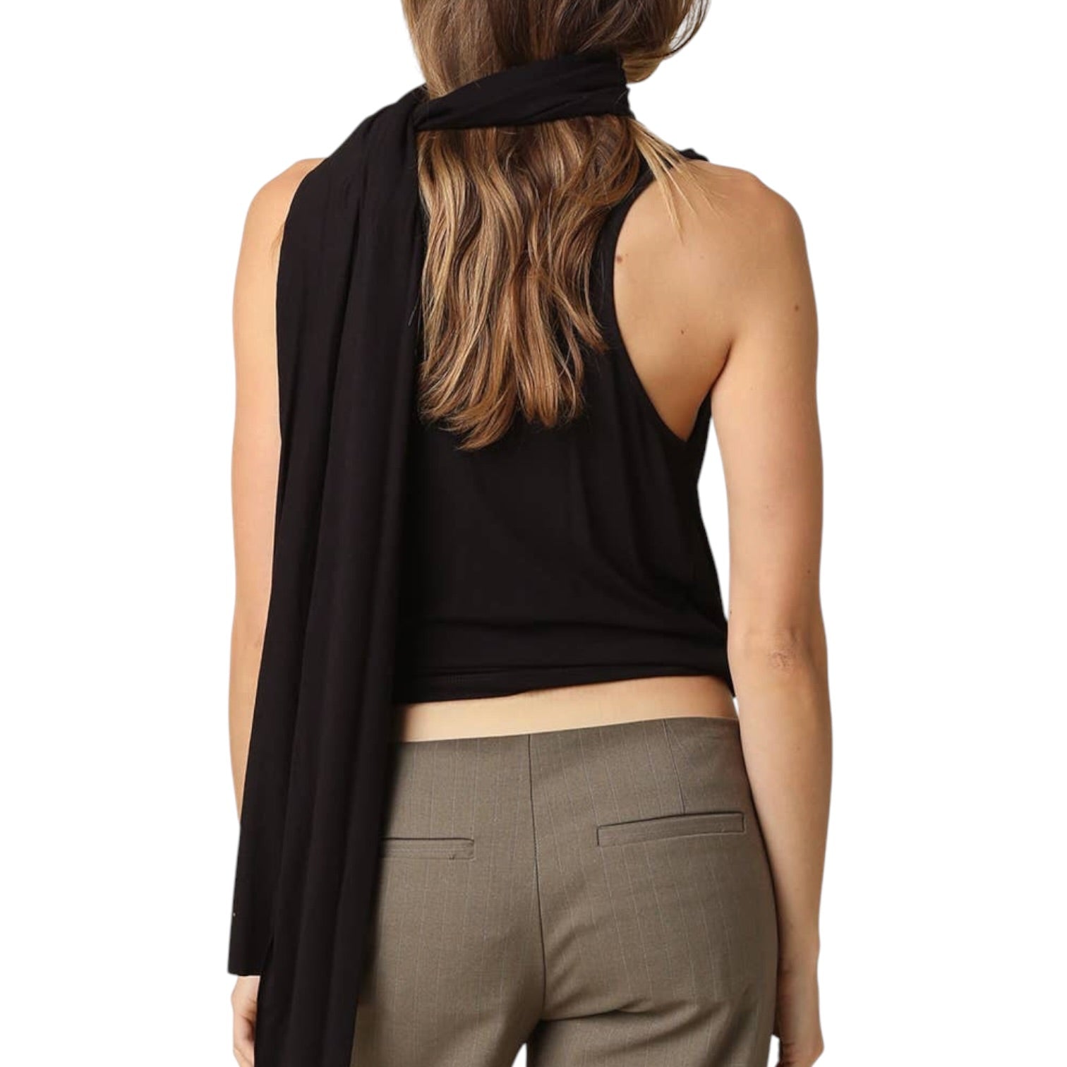 Woman wearing a black sleeveless top and brown pants on a white background