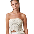 Model wearing a crochet flyaway tube top with intricate detailing, showcasing a bohemian style.