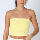 Yellow floral lace tube top on model, showcasing strapless design and elegant feminine style.