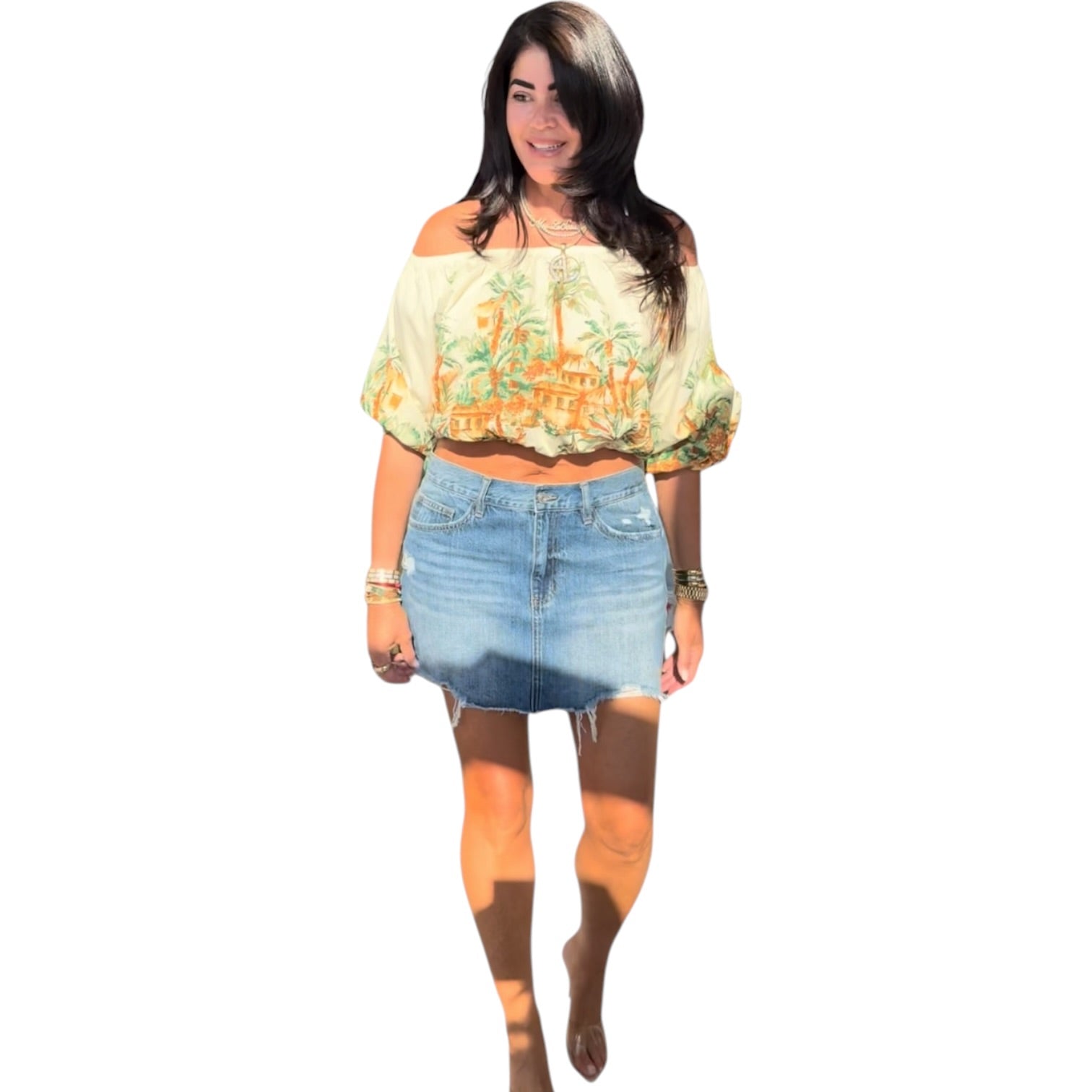 Woman wearing a floral top and denim skirt on a white background