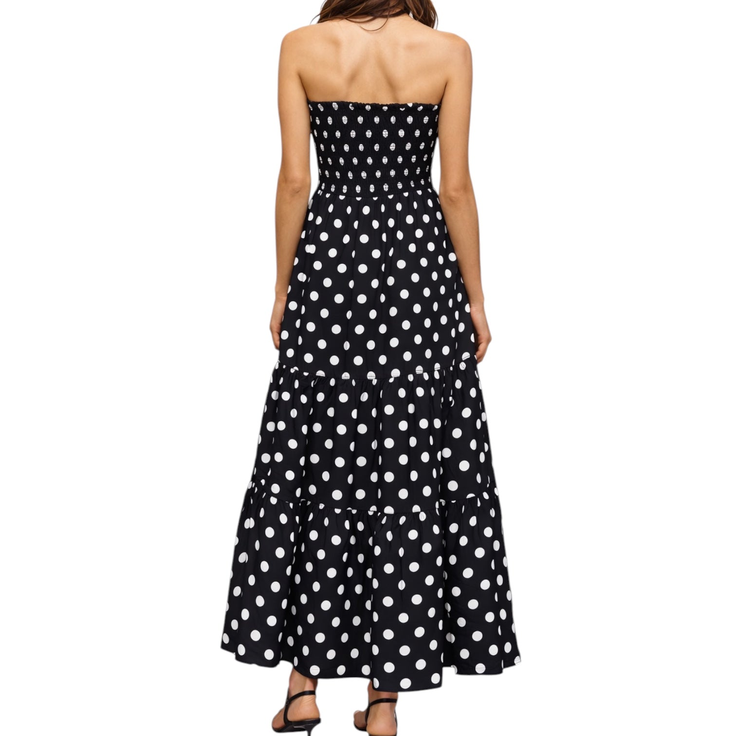Black strapless dress with white polka dots on a white background