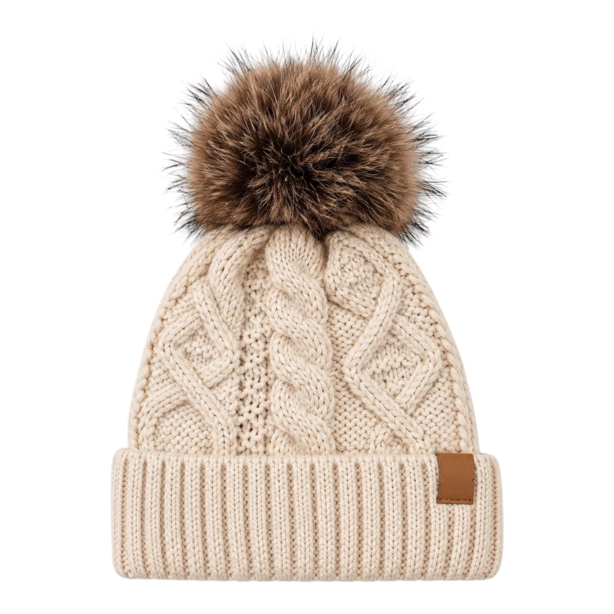 A cream-colored cable-knit beanie hat featuring a large brown faux-fur pom-pom on top and a small brown leather brand tab on the side cuff, shown against a plain white background.