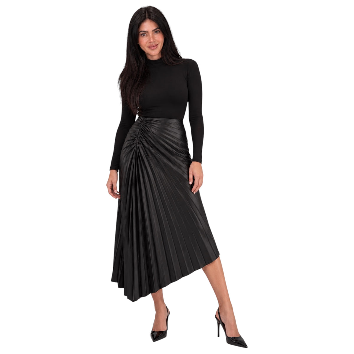 A woman modeling a black long-sleeve mock-neck top paired with a black pleated faux-leather midi skirt and black pointed-toe heels, set against a plain white background.
