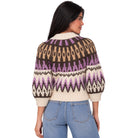 A woman shown from the back wearing a cream, brown, and purple patterned knit sweater with balloon sleeves, paired with light blue jeans, against a plain white background.