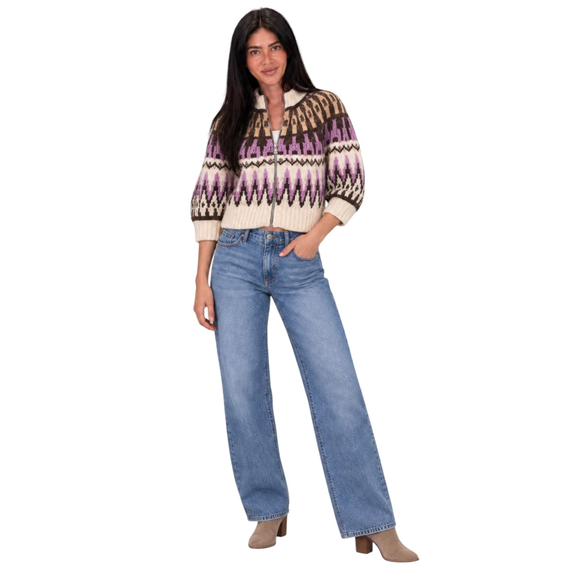 A woman modeling a cream knit cardigan with a purple, brown, and black geometric pattern, paired with light-wash blue jeans and beige ankle boots, against a solid white background.