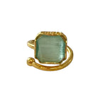 Gold ring with a green gemstone on a white background