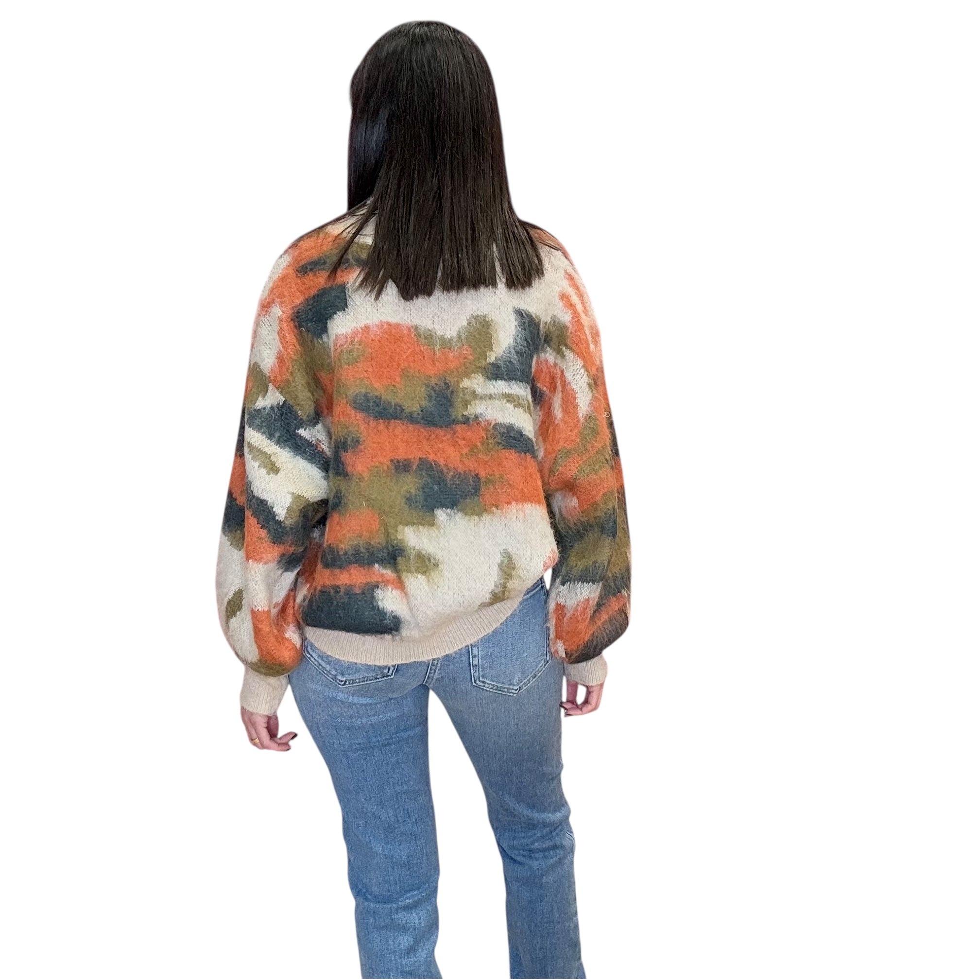 Person wearing a colorful sweater and jeans on a white background