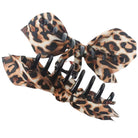 Two leopard print hair claw clips with black plastic teeth and a matching fabric bow, shown on a plain white background.