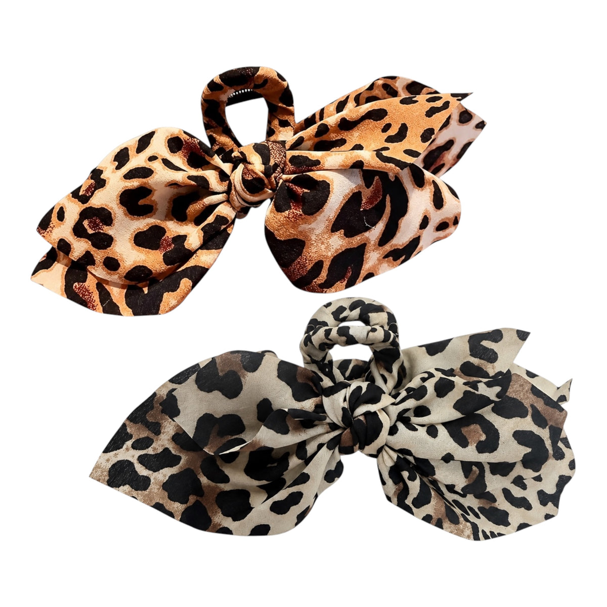 Two leopard print hair bow clips on a plain white background, one in tan and brown with black spots and one in beige and brown with black spots.