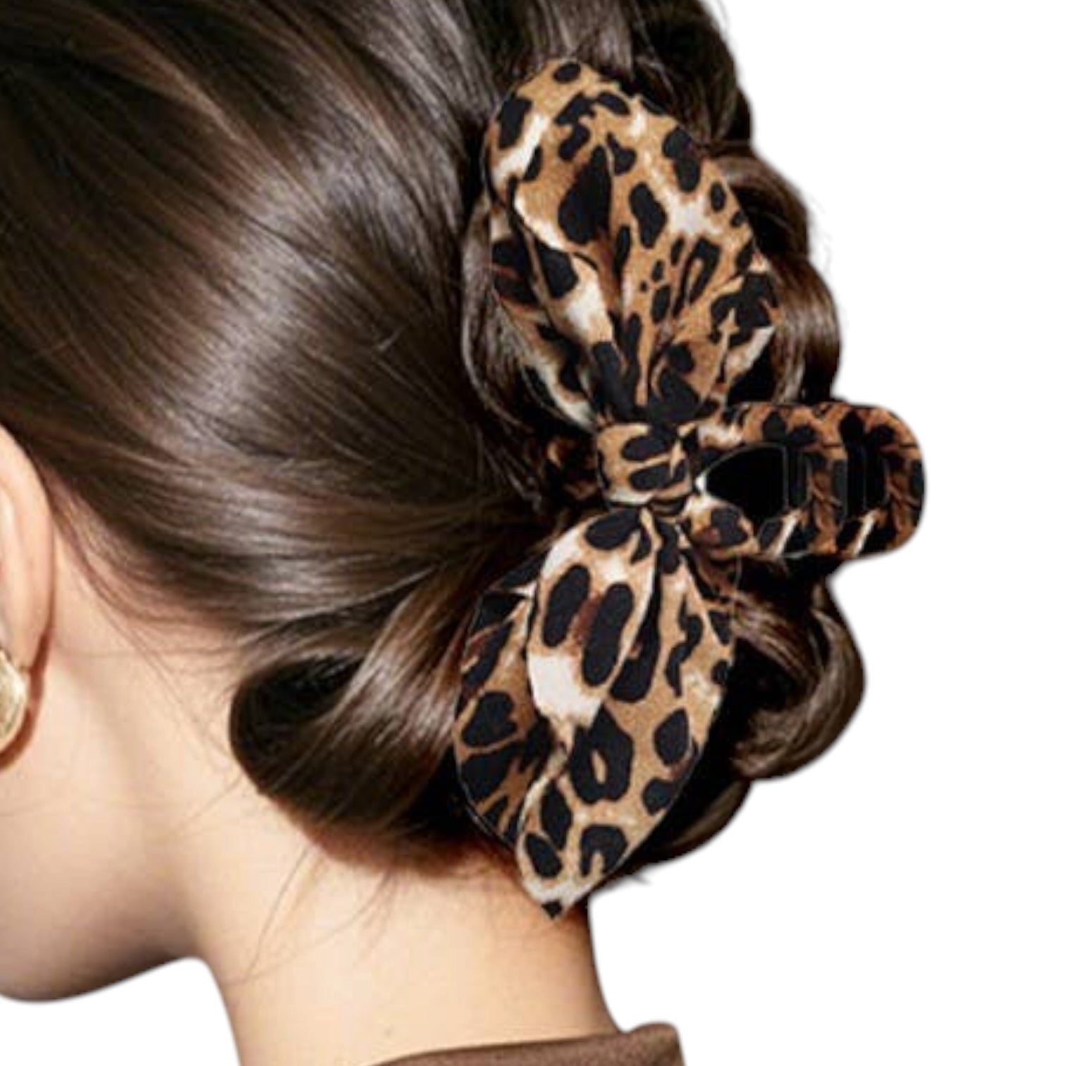 A leopard print hair claw clip styled in a braided bun on a model's hair, shown against a plain white background.