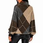 A woman shown from the back wearing a fuzzy argyle sweater with brown, beige, and gray diamonds outlined in white, paired with black leggings, against a plain white background.
