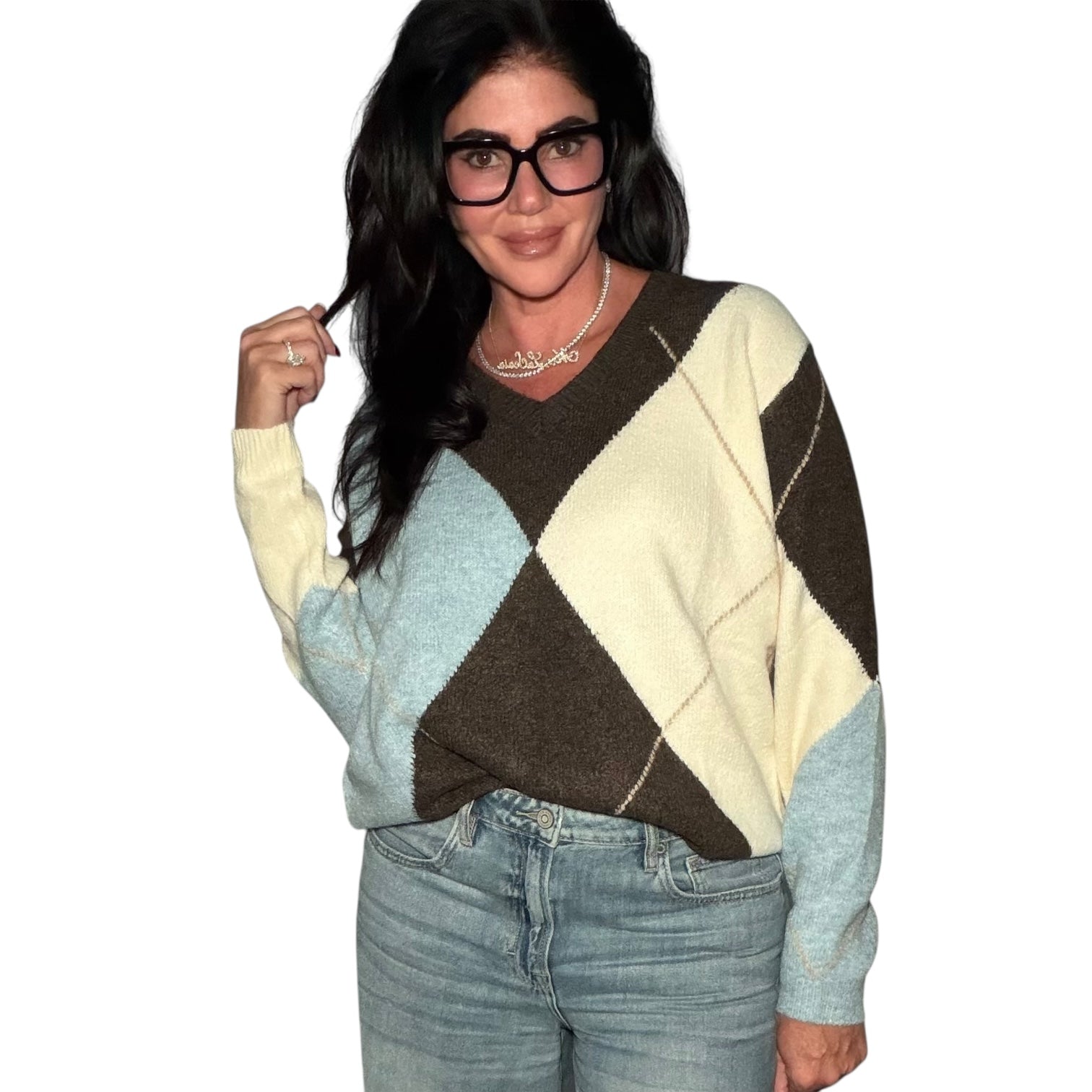 Person wearing a diamond pattern sweater with a plain background