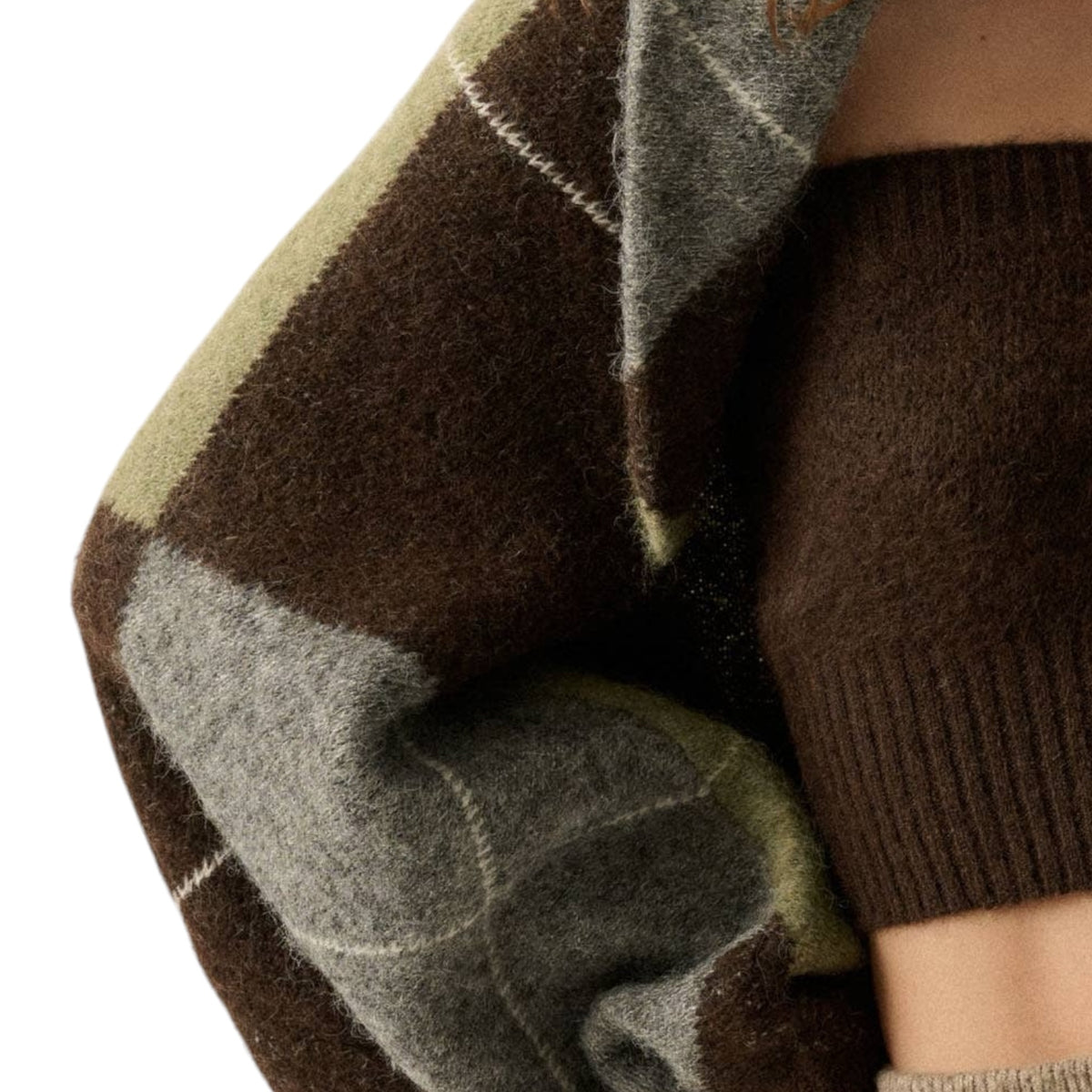 Close-up of a person wearing a chunky knit sweater with a brown, gray, and muted olive plaid pattern, paired with a solid dark brown ribbed knit sleeve or undershirt.
