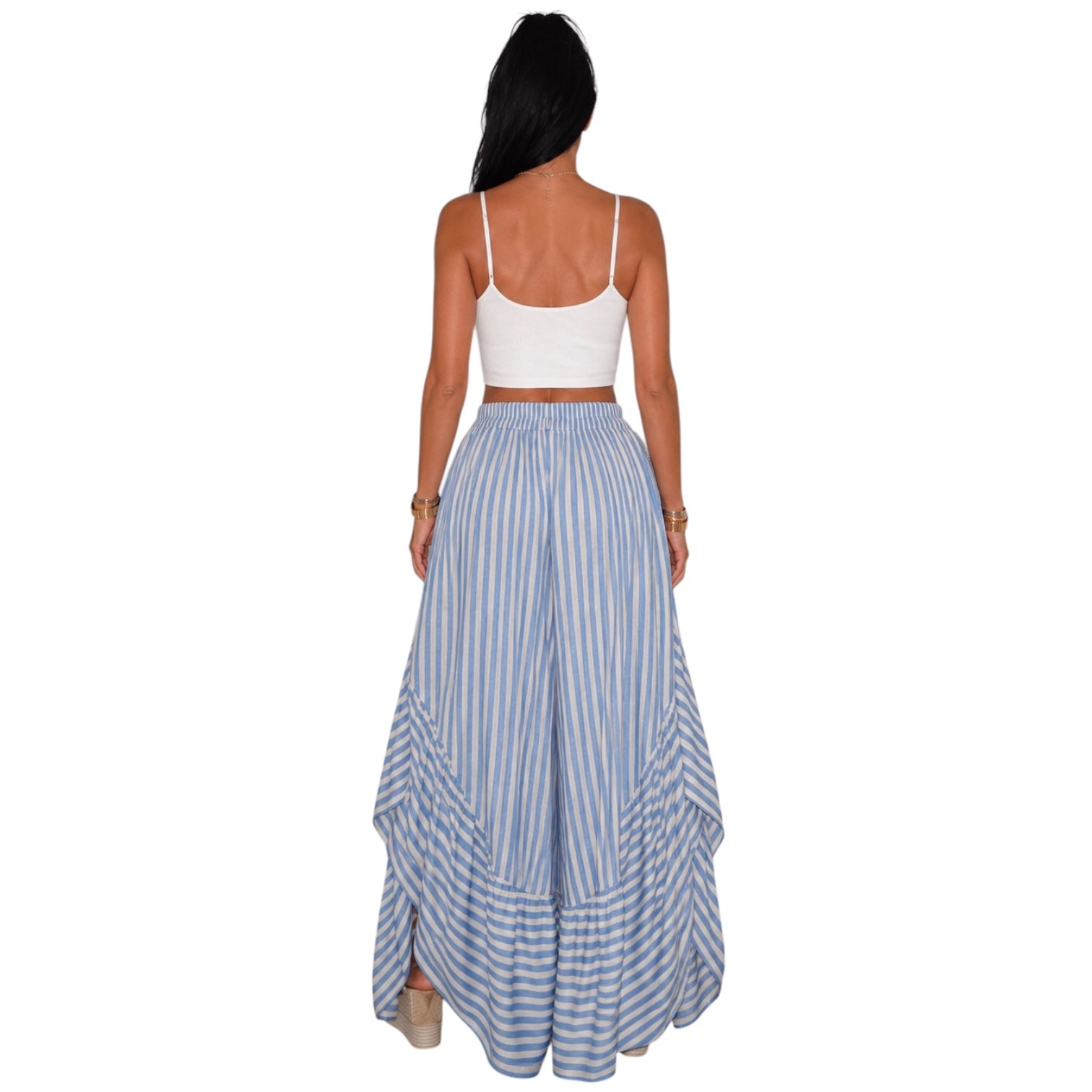A woman shown from the back wearing a white spaghetti-strap crop top and high-waisted, wide-leg maxi skirt with vertical blue and white stripes.