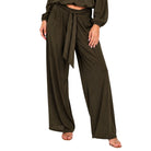 A person wearing loose, wide-leg olive green pants with a tied waist and a matching long-sleeve cropped top, shown against a plain white background.