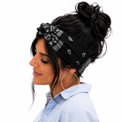 Woman wearing a black bandana with white patterns on her head, against a white background