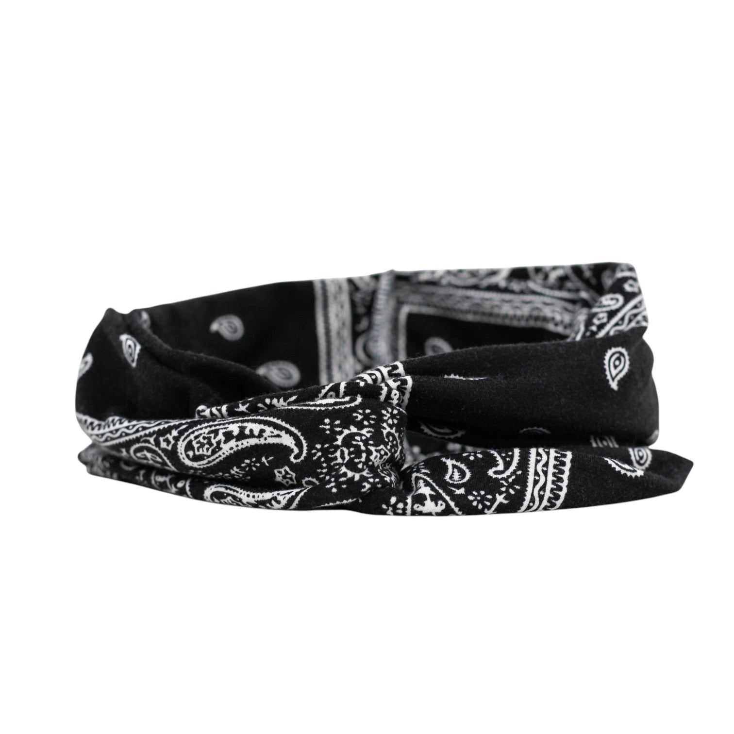 Woman wearing a black bandana with white patterns on her head, against a white background