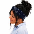 Woman wearing a navy blue bandana with white patterns on her head, against a white background.
