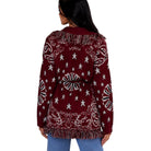 A woman shown from the back wearing a burgundy cardigan sweater with white star and paisley patterns and fringe trim, paired with blue jeans against a white background.
