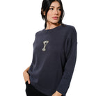 Woman wearing a navy sweater with a martini glass design on a white background